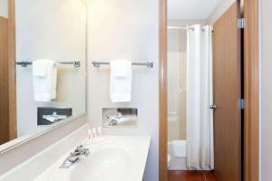 a white bathroom with a sink and a mirror at Super 8 by Wyndham Gilman in Gilman +26 photos