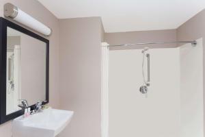 a bathroom with a shower and a sink and a mirror at Super 8 by Wyndham Green River in Green River