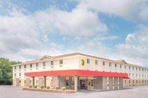 a large white building with a red awning at Super 8 by Wyndham Terre Haute in Terre Haute