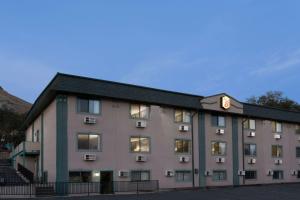 a large apartment building with a black roof at Super 8 by Wyndham Green River in Green River