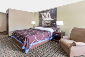a hotel room with a bed and a chair at Super 8 by Wyndham Logansport in Logansport