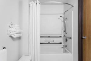 un bagno bianco con doccia e WC di Super 8 by Wyndham Dumfries/Quantico a Dumfries Altre 4 foto