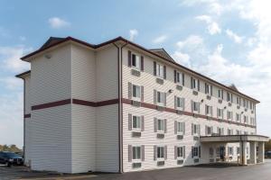 a large white building with a gambrel roof at Super 8 by Wyndham Springfield East in Springfield