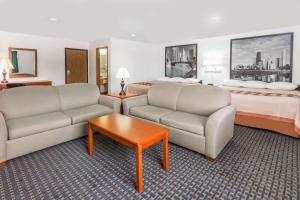 a hotel room with a couch and a bed at Super 8 by Wyndham Rock Falls Sterling Area in Rock Falls