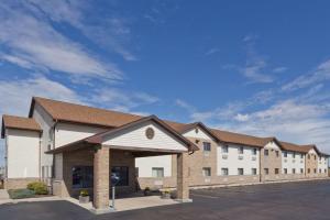 a large white building with a brown roof at Super 8 by Wyndham Rochelle in Rochelle