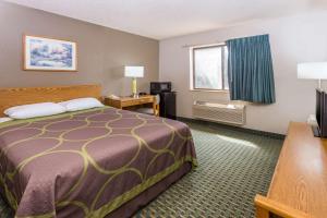 a small hotel room with a bed and a window at Super 8 by Wyndham St. Charles in Saint Charles
