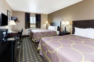 a hotel room with two beds and a flat screen tv at Super 8 by Wyndham Springfield East in Springfield