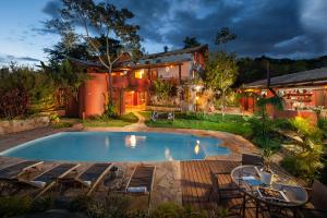a house with a swimming pool in the yard at Pousada Maya in Alto Paraíso de Goiás