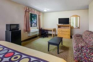 a hotel room with a couch and a television at Super 8 by Wyndham Sherman in Sherman
