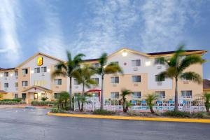 un hotel con palmeras frente a un edificio en Super 8 by Wyndham Clearwater/St. Petersburg Airport, en Clearwater