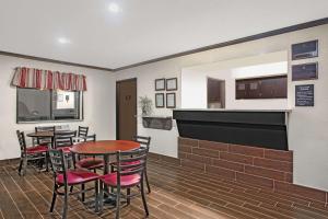 a dining room with tables and chairs and a kitchen at Super 8 by Wyndham Douglas in Douglas