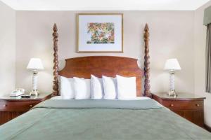 a bed in a hotel room with two night stands at Days Inn by Wyndham Kingman East in Kingman +26 photos
