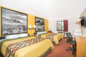 a hotel room with two beds and a desk at Super 8 by Wyndham Elko in Elko