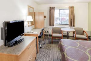 a hotel room with a flat screen tv and a bed at Super 8 by Wyndham Bend in Bend