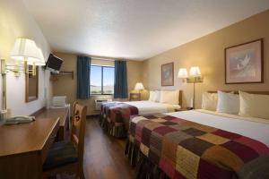 Una habitación de hotel con dos camas y un escritorio. en Super 8 by Wyndham Las Vegas, en Las Vegas