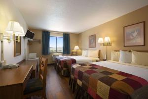 a hotel room with two beds and a desk at Super 8 by Wyndham Las Vegas in Las Vegas