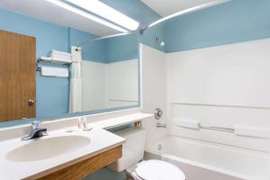 a bathroom with a sink and a toilet and a mirror at Super 8 by Wyndham Cedar City in Cedar City