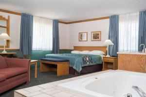 a hotel room with a bed and a bath tub at Super 8 by Wyndham Sheldon in Sheldon