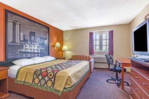 a hotel room with a bed and a flat screen tv at Super 8 by Wyndham New Orleans in New Orleans