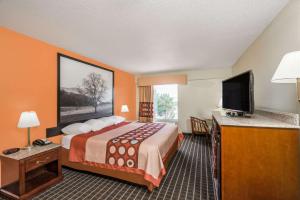 a hotel room with a bed and a flat screen tv at Super 8 by Wyndham Dandridge in Dandridge