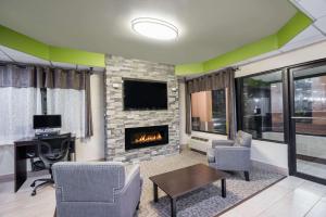 sala de estar con chimenea y TV en Super 8 by Wyndham Knoxville West/Farragut en Knoxville