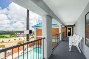 a balcony with white chairs and a pool at Super 8 by Wyndham Dandridge in Dandridge