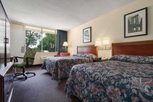 a hotel room with two beds and a desk and a chair at Super 8 by Wyndham Dover in Dover