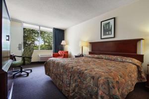 a hotel room with a bed and a chair at Super 8 by Wyndham Dover in Dover