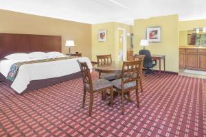 a hotel room with a bed and a table and chairs at Super 8 by Wyndham Kerrville TX in Kerrville