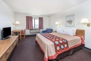 a hotel room with a bed and a flat screen tv at Super 8 by Wyndham Du Quoin in Du Quoin