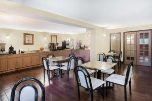 a restaurant with tables and chairs and a kitchen at Super 8 by Wyndham Oxford in Oxford