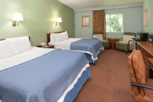 a hotel room with two beds and a television at Days Inn by Wyndham Portage in Portage