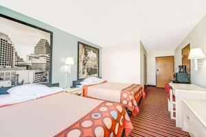 Habitación de hotel con 2 camas y lavamanos en Super 8 by Wyndham San Antonio/Fiesta, en San Antonio