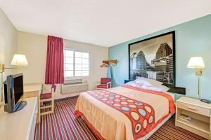 a hotel room with a bed and a desk at Super 8 by Wyndham San Antonio/Fiesta in San Antonio +17 photos