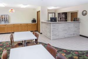 a waiting room with two tables and a counter at Super 8 by Wyndham Pekin/Peoria Area in Pekin