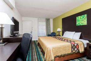 a hotel room with a bed and a television at Super 8 by Wyndham Augusta in Augusta