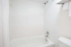a white bathroom with a tub and a sink at Super 8 by Wyndham Augusta in Augusta +43 photos