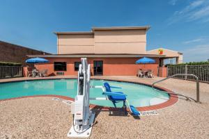 a swimming pool at a hotel with a pool house at Super 8 by Wyndham Fort Worth North in Fort Worth