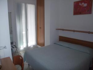 a bedroom with a blue bed and a window at Hotel Adriana in Laigueglia