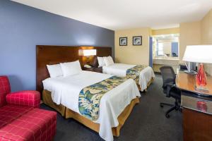 a hotel room with two beds and a desk and a chair at Days Inn by Wyndham Walterboro in Walterboro +13 photos