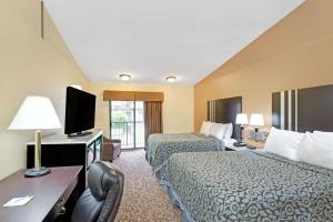 Days Inn by Wyndham Washington في واشنطن: غرفة فندقية بسريرين وتلفزيون بشاشة مسطحة