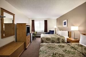 una camera d'albergo con due letti e una televisione di Days Inn by Wyndham Billings a Billings