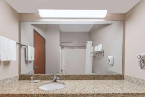 a bathroom with a sink and a large mirror at Super 8 by Wyndham Fort Worth North in Fort Worth +11 photos