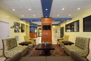 a lobby with chairs and a table and a tv at Days Inn by Wyndham Fultondale in Fultondale