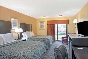 Days Inn by Wyndham Washington في واشنطن: غرفة فندقية بسريرين وتلفزيون بشاشة مسطحة