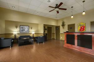 a waiting room with couches and a ceiling fan at Super 8 by Wyndham-Tupelo Airport in Tupelo