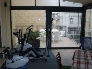 a gym with two exercise bikes and a balcony at Hotel Adriana in Laigueglia