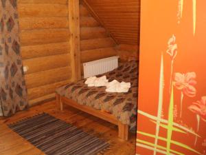 1 dormitorio con 1 cama en una habitación de madera en Visdari, en Rumbula