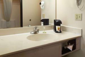 Un baño con lavabo y un espejo grande. en Super 8 by Wyndham Colorado Springs Airport, en Colorado Springs
