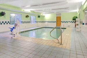 a large swimming pool in a large room with at Super 8 by Wyndham Pontoon Beach IL/St. Louis MO Area in Pontoon Beach